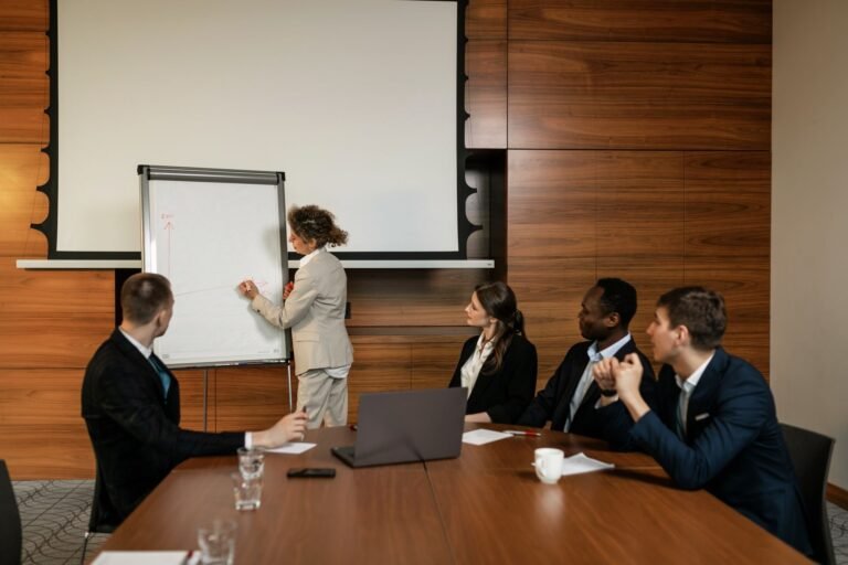 A professional team engaged in a conference room meeting with a presentation.