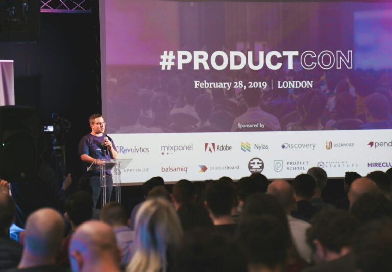A man speaking on stage giving a presentation to an audience