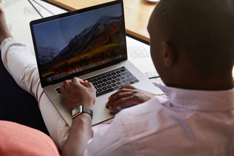 Back view of anonymous African American businessman watching laptop while working on project