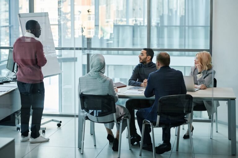 A diverse group engages in a collaborative meeting in a modern office setting, fostering teamwork and creativity.