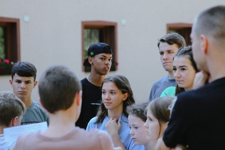 Teenagers gathered outdoors engaged in a lively discussion, fostering communication and learning.