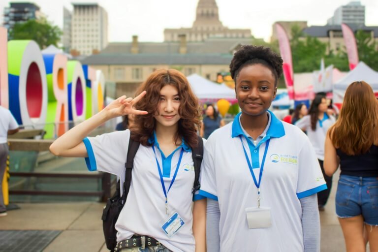Two young women smiling at an outdoor event.
